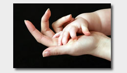 Hands of infant and mother