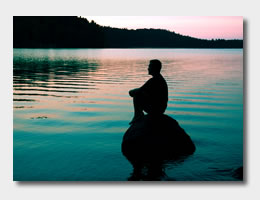 Person meditating on a rock